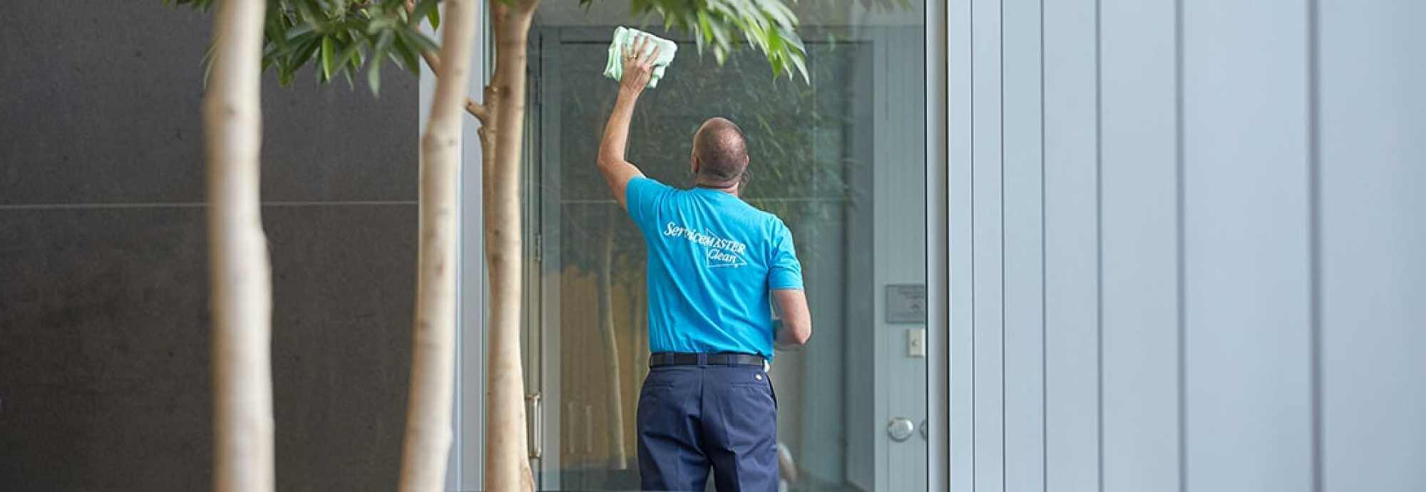 janitorial office cleaning with a man cleaning windows